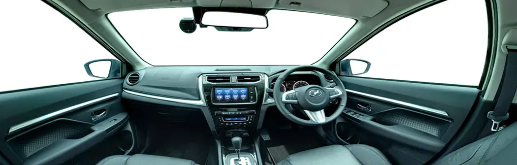 Perodua car rolling past slowly, wheels in focus for a smooth, composed motion feel.