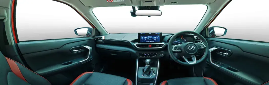 Perodua car rolling past slowly, wheels in focus for a smooth, composed motion feel.